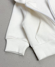 Casaco Moletom Capuz Zíper Peluciado Off-White MiniMalista — vista de costas mostrando o capuz amplo e a barra em ribana ajustada. 100% algodão fio penteado com interior peluciado quentinho, tratamento anti-pilling.