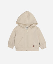 Casaco Moletom Peluciado Liso Beige MiniMalista Baby — vista frontal do casaco infantil unissex em bege claro neutro. 100% algodão antialérgico, capuz peluciado sem cordinha, zíper com cobre-zíper interno. Corte folgado pra usar sobre body canelado. Do bebê de 0-3 meses à criança de 5-6 anos.