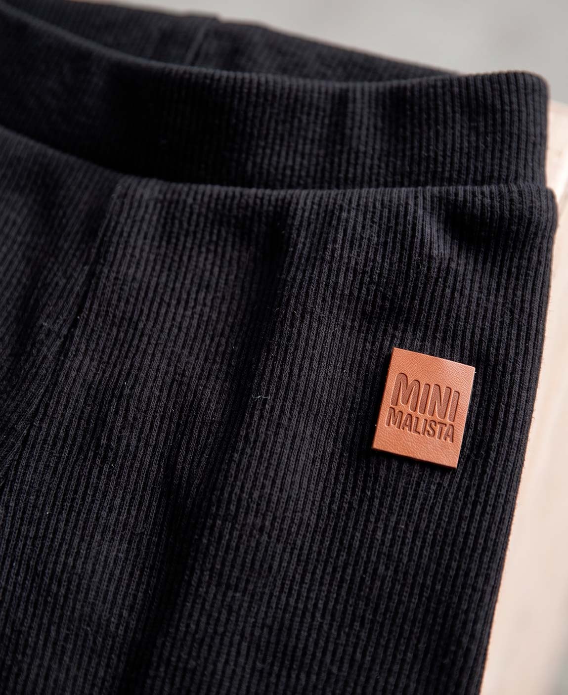 Body Canelado Manga Longa Bebê Liso Preto MiniMalista — placket frontal com botões metálicos elegantes, botões entrepernas facilitando troca de fralda, algodão canelado respirável fitted.