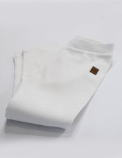 Calça Canelada Slim Liso Branco Off MiniMalista — calça infantil unissex 100% algodão em ribana, caimento slim ajustado, branco off atemporal que combina com qualquer estampa e cor, do bebê de 0-3 meses aos 5-6 anos.