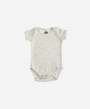 MiniMalista Body de Bebê Manga Curta Unissex em Bolinhas Claro, vista frontal. Bolinhas delicadas sobre Branco Off, 100% algodão fio egípcio, gola americana e 3 botões entrepernas. Body de bebê unissex para menino e menina.